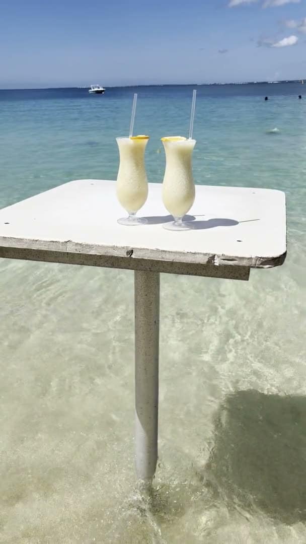 Table de bar installée dans l'eau turquoise d'une plage de Saint-Martin